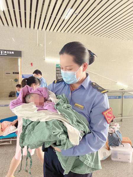 客运员邓锦波在悉心照顾出生小孩，等待转移至急救车上。沙柱婵摄
